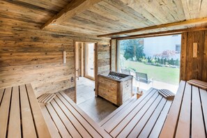 A wooden interior with a wooden bench, a small table, and a view of the outdoors. - Type 5 - 2 bedrooms 1 bunk bed & 1 double bed, 4-6 pax - Pepi's Suites (Holzgau)