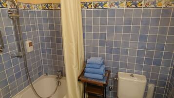 Une salle de bain équipée d’une baignoire, de toilettes et d’un espace douche.