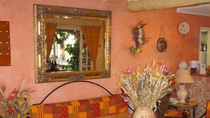 Un comedor con una mesa estampada, bancos acolchados y un jarrón de flores.