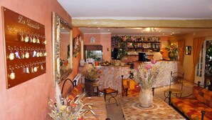Un ambiente acogedor con una zona de bar, asientos y una exhibición de objetos decorativos.