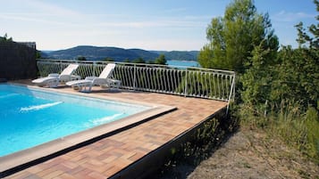 En sÀsongsöppen utomhuspool och solstolar