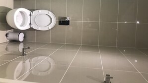 Ett modernt badrum med toalett, bidé och handtork.