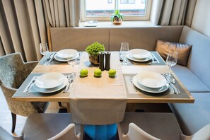 A dining area with a table set for four, including plates, cutlery, and glasses.