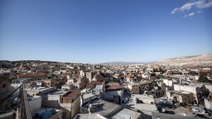 A panoramic view of a densely packed urban area with numerous buildings and rooftops, under a clear blue sky. - Kookaburra Hotel (Nevsehir)