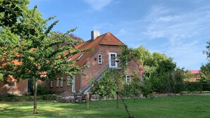 A brick house with a red-tiled roof, a chimney, and a small staircase leading to the entrance. - Vacation on the manor - small cozy apartment near the Baltic Sea (Waabs)