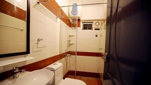 A small bathroom with a sink, toilet, and shower. - Cherry Blossom Homestay (Kodaikanal)
