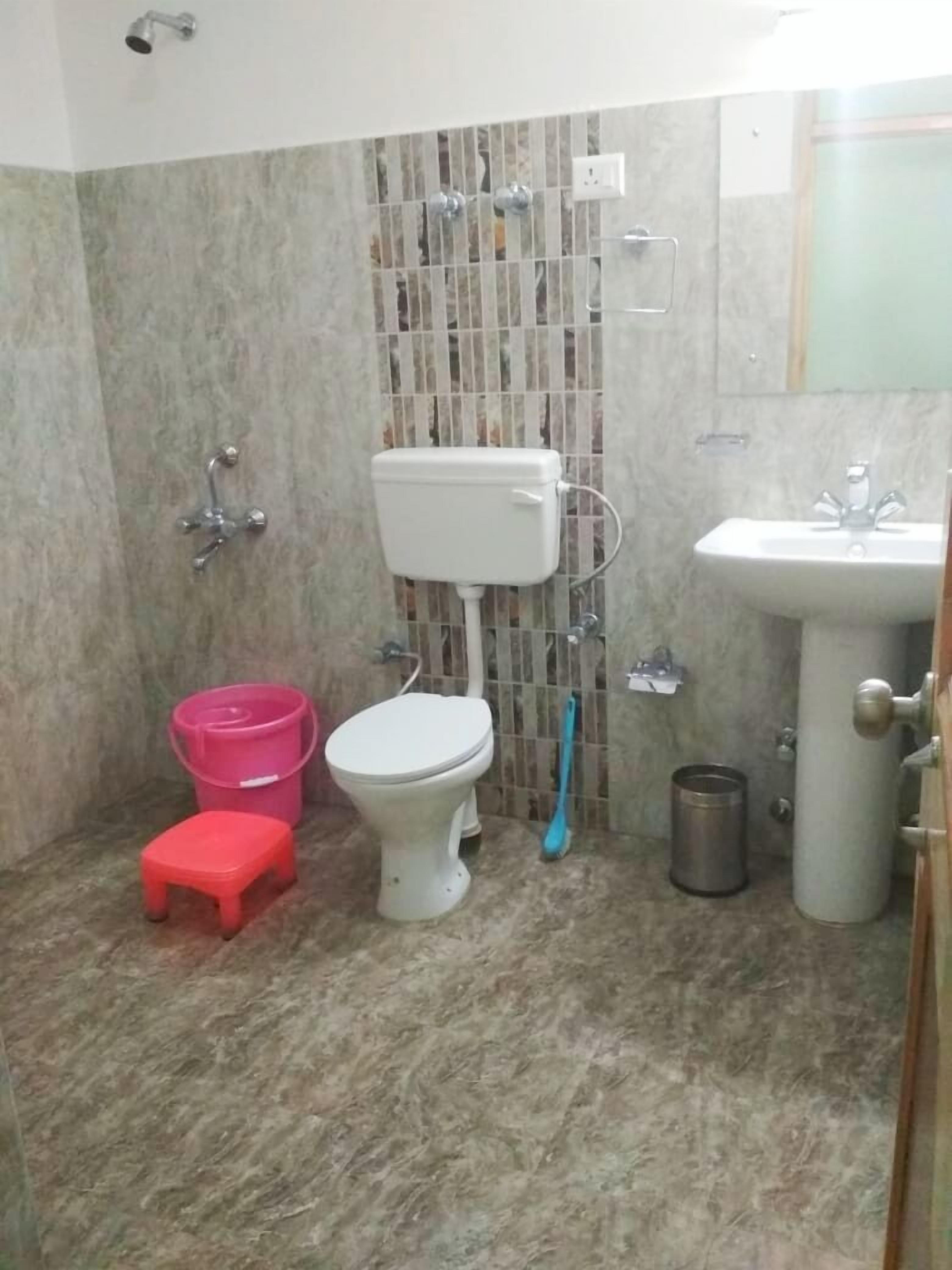 A small bathroom with a toilet, sink, and a shower.