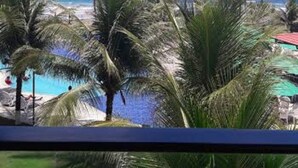 A view of a beach with palm trees and a clear blue sky. - Anchor Flat Resort, beachfront, 2 km from the village of Porto de Galinhas, sleeps 6.  (Ipojuca - Porto de Galinhas)