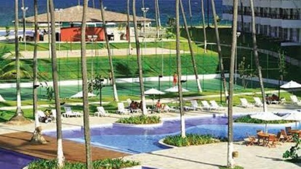 A resort with a pool area, palm trees, and a view of the ocean. - Anchor Flat Resort, beachfront, 2 km from the village of Porto de Galinhas, sleeps 6.  (Ipojuca - Porto de Galinhas)