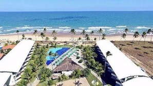 A resort with a pool, palm trees, and a beach view. - Anchor Flat Resort, beachfront, 2 km from the village of Porto de Galinhas, sleeps 6.  (Ipojuca - Porto de Galinhas)