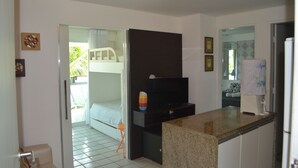 A compact hotel room with a kitchenette, a bed, and a bathroom. - Anchor Flat Resort, beachfront, 2 km from the village of Porto de Galinhas, sleeps 6.  (Ipojuca - Porto de Galinhas)