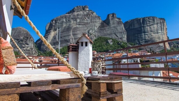 A coastal terrace with a rope barrier, a small white tower, and rocky cliffs in the background. - Tasos House_Panoramic View  (Kalabaka)