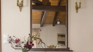 A dark wooden console table with a mirror above it, flanked by wall sconces. - Tasos House_Panoramic View  (Kalabaka)