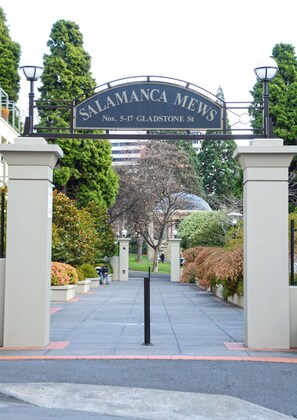 Une entrée fermée par un portail, sur laquelle est apposée une plaque indiquant : « Salamanca Mews, numéros 5 à 17, rue Gladstone ».