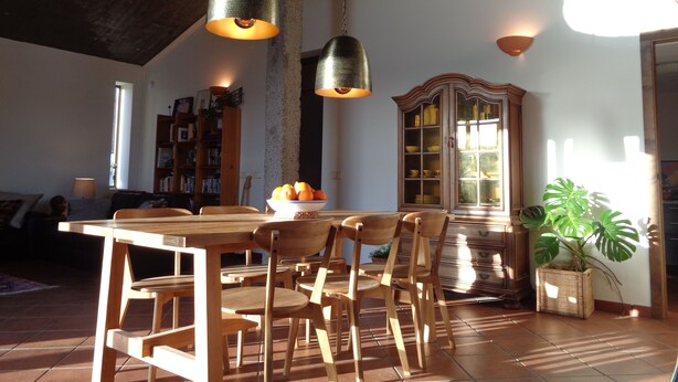 Un comedor con muebles de madera, lámparas colgantes y un armario con puertas de cristal.