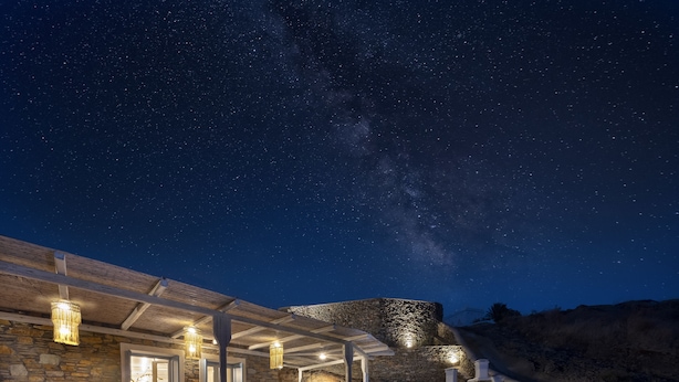 A stone building with a covered patio, outdoor seating, and lanterns. - Simousi Villas (Kithnos)