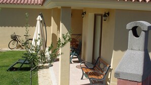 A patio with a grill, a bicycle, and outdoor seating. - SHORT TERM LET IN SARDINIA, HOLIDAY HOME OLBIA-PITTULONGU WITHIN 5MIN FROM BEACH (Olbia)