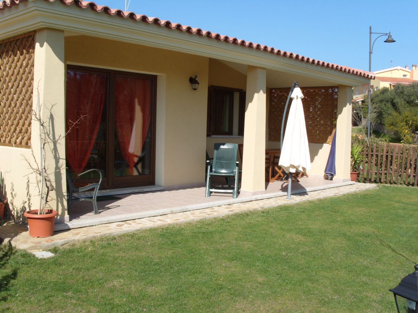 A house with a covered patio, a sliding glass door, a chair, and a table.