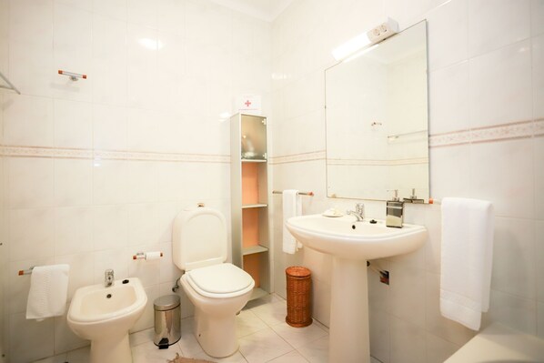 A modern bathroom with a toilet, bidet, sink, and a mirror. - Sotto Mayor Residence (Figueira da Foz)