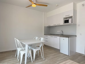 A modern kitchen with white cabinetry, a built-in microwave, and a dishwasher.