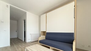 Ett modernt rum med en soffa, ett litet bord och ett element.
