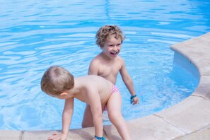 Ein Swimmingpool mit klarem, blauen Wasser und einer Steinkante.