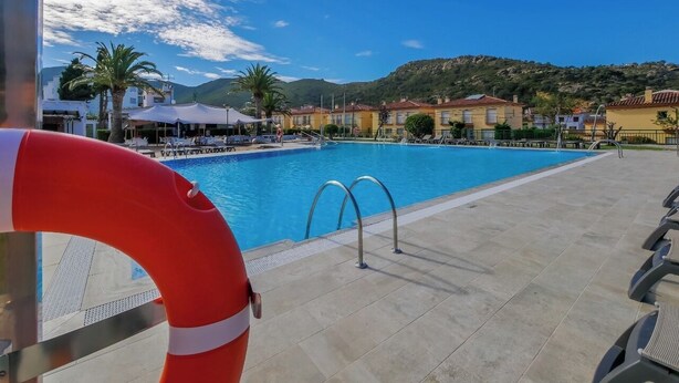 Une piscine à l’eau d’un bleu cristallin, entourée d’une terrasse carrelée et agrémentée d’une bouée de sauvetage.