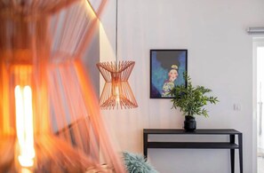 Simple elegance defines this interior space with a console table, artwork, and lush greenery.