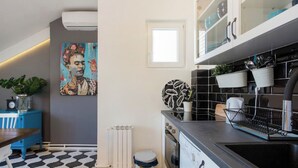 A modern kitchen with a black and white patterned floor, a white radiator, a trash bin, and a painting on the wall. - Amazing design, Huge, Prime location, With Parking (Stari Grad)