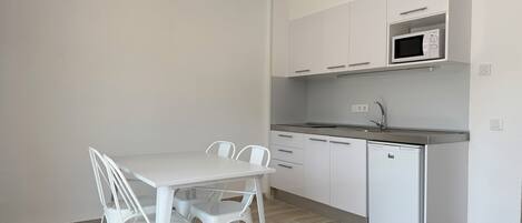 A modern kitchen with white cabinetry, a built-in microwave, and a dishwasher.