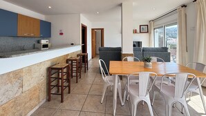 Une cuisine moderne dotée de plans de travail en granit, d’armoires en bois et d’un four à micro-ondes encastré.