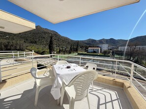A terrace with a table set for two, overlooking a mountainous landscape. - Agi Rescator 306 Apartamento for rent in Roses Girona. (Rosas / Roses)