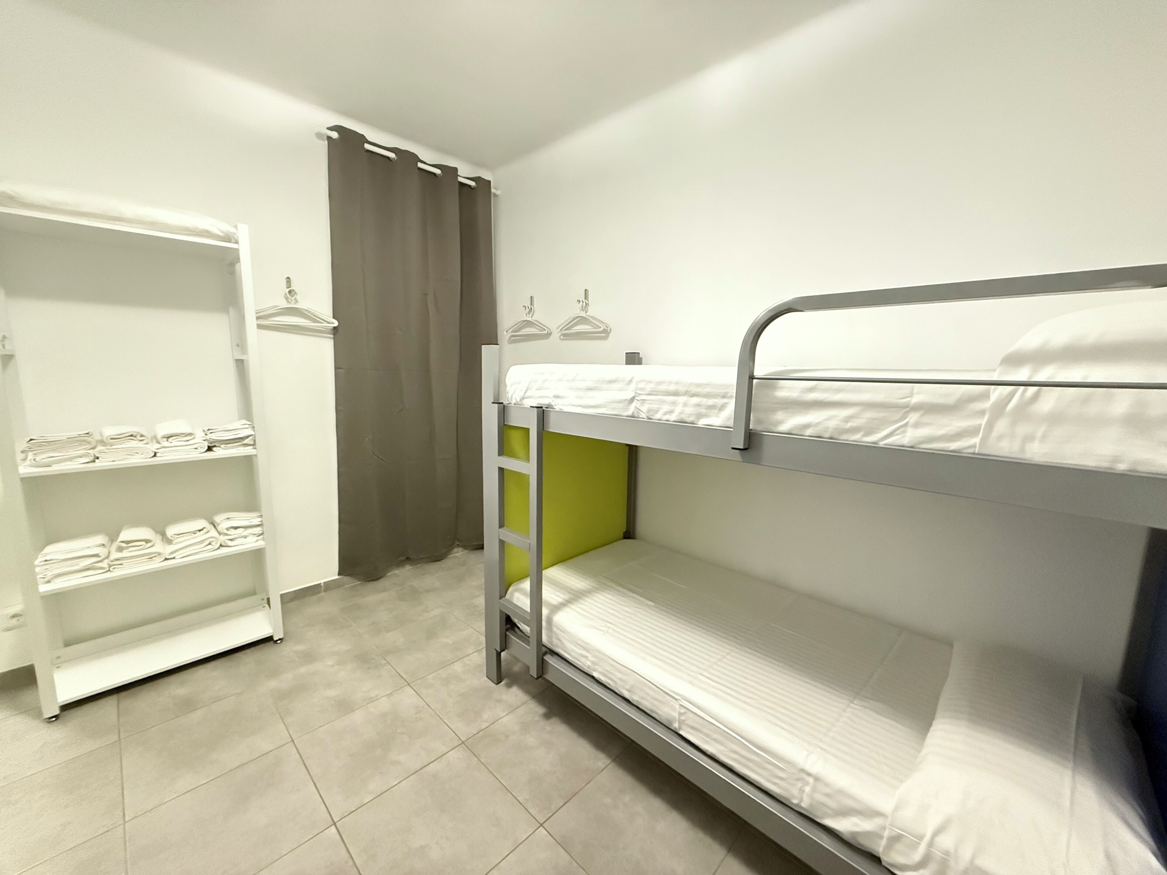 A bunk bed room with a wardrobe and shelves.