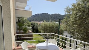 A balcony with a table and chairs, overlooking a mountainous landscape. - Agi Rescator 214 Apartamento for rent in Roses Girona. (Roses)