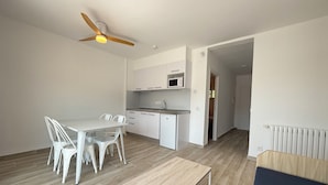 A modern kitchen with white cabinets, a microwave, and a ceiling fan. - Agi Rescator 318 Apartamento for rent in Roses Girona. (Rosas / Roses)