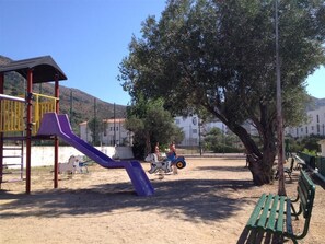 Kids can play on the slide and horse-shaped ride-on toy in this outdoor playground area surrounded by trees and scenic views.