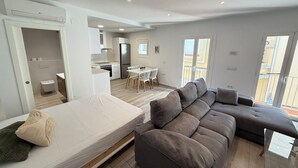En moderne lejlighed med opholdsstue, tekøkken og balkon.