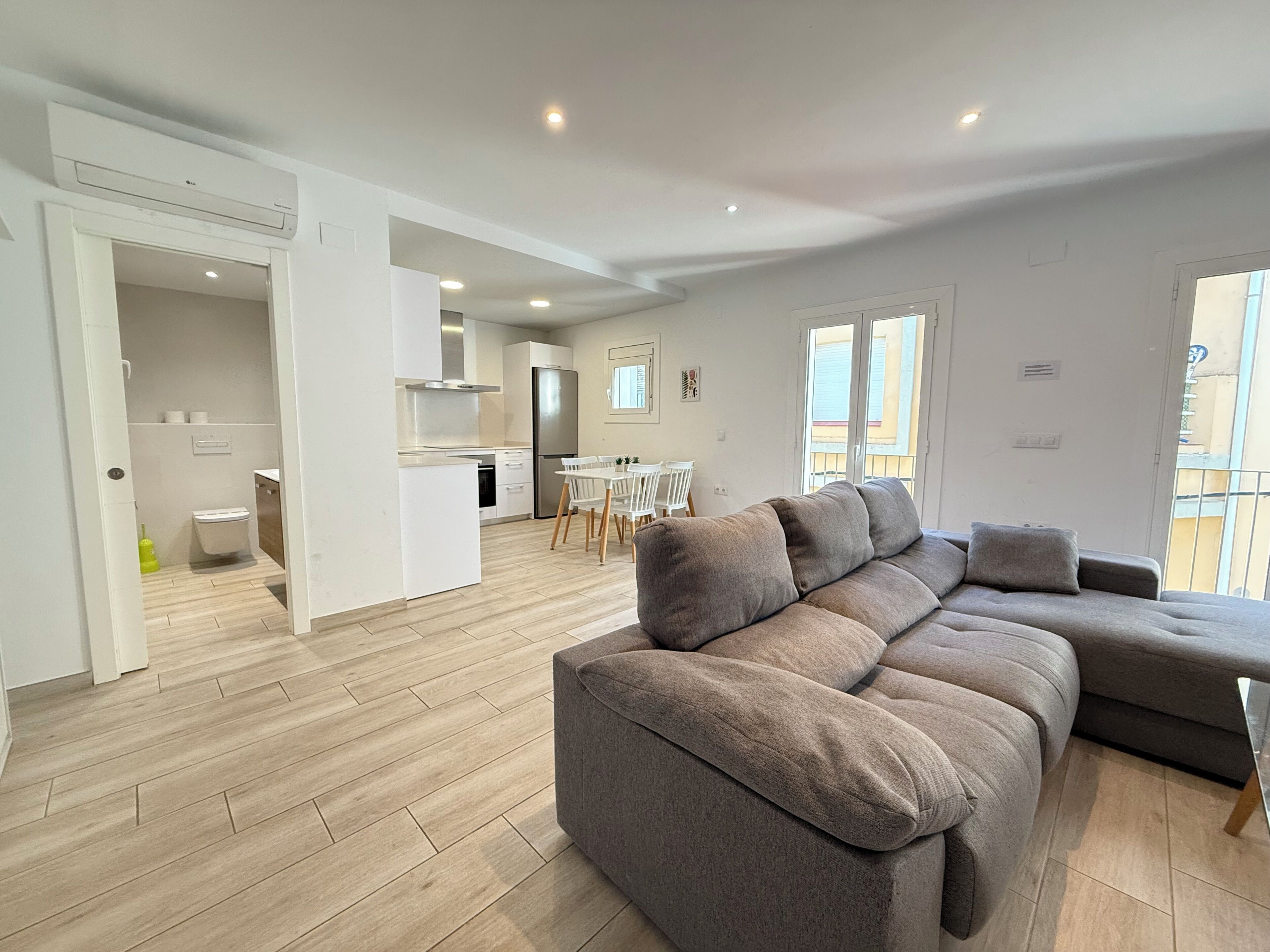 Un appartement moderne comprenant un espace de vie, une cuisine et un coin repas.
