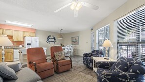 A compact living space with a kitchenette, a dining area, and a seating area with a ceiling fan.
