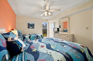 Een slaapkamer met een bed, een kapstok, een plafondventilator en een raam met uitzicht op een woonwijk.