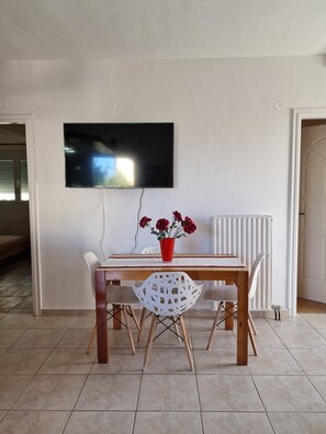 Enjoy meals in this dining area with a wooden table, two chairs, and a flat-screen TV.
