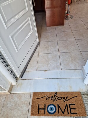 Enter a warm and inviting space with a traditional door and a personalized welcome mat.