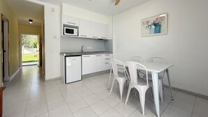 Una cocina moderna con armarios blancos, un microondas y un ventilador de techo.