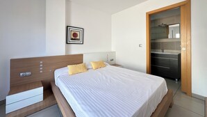 Une chambre à coucher moderne avec une tête de lit en bois, un lit blanc avec une literie à rayures et une petite table de chevet.