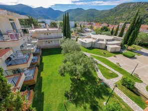 Zona residencial con edificios de varios pisos, un césped bien cuidado y una vista despejada de las montañas circundantes.