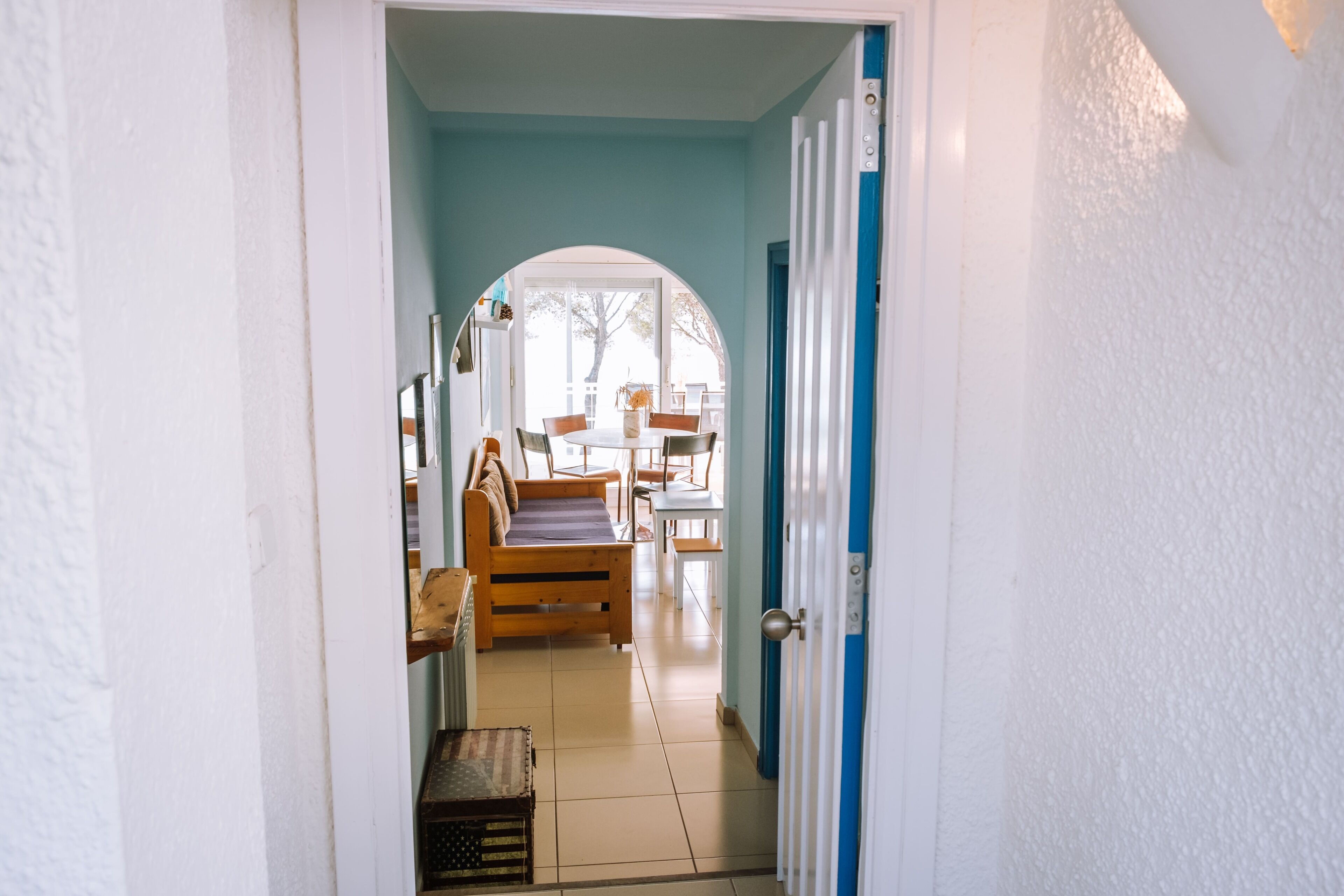 A hallway leading to a dining area with a round table and chairs.