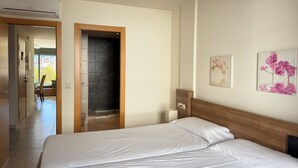 A hotel room with a large bed, a shower, and a view of the city. - Agi Riera Ginjolers 3B Apartamento for rent in Roses Girona. (Roses)