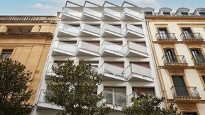 Un edificio moderno con una facciata geometrica particolare e numerosi balconi.