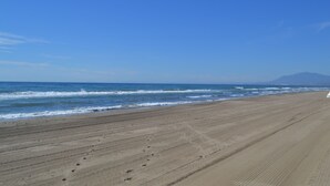 A wide sandy beach with gentle waves and a clear blue sky. - URBANIZATION ALICATE PLAYA. (Marbella)