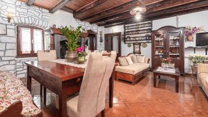 Ein gemütliches Wohnzimmer mit einem Holzesstisch, einer Couch und einem Fernseher.